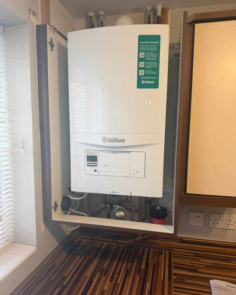 A new Vaillant ecoTEC Pro 28 boiler fitted by Graham in a kitchen wall cupboard, with copper pipework and a magnetic system filter below